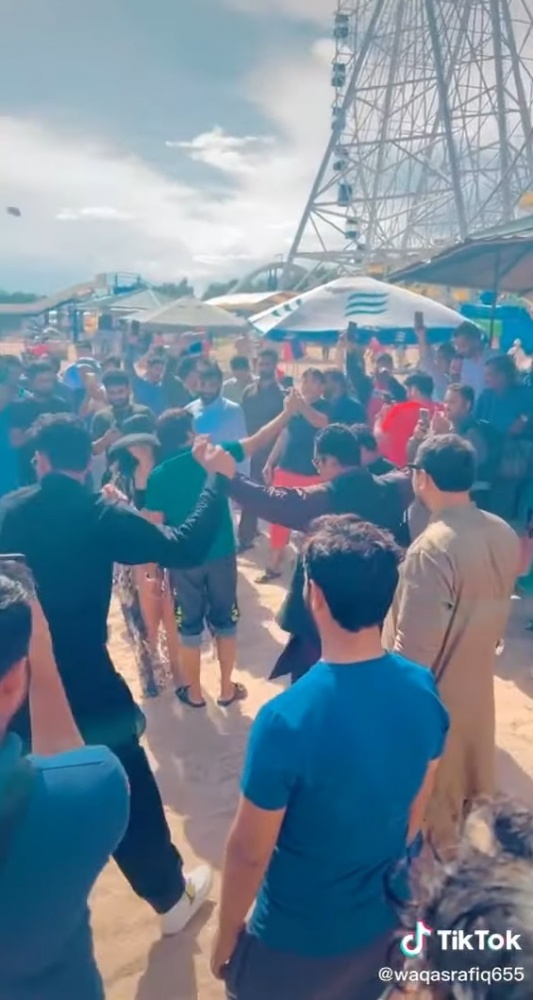 Туристы из Пакистана танцуют на пляже Иссык-Куля